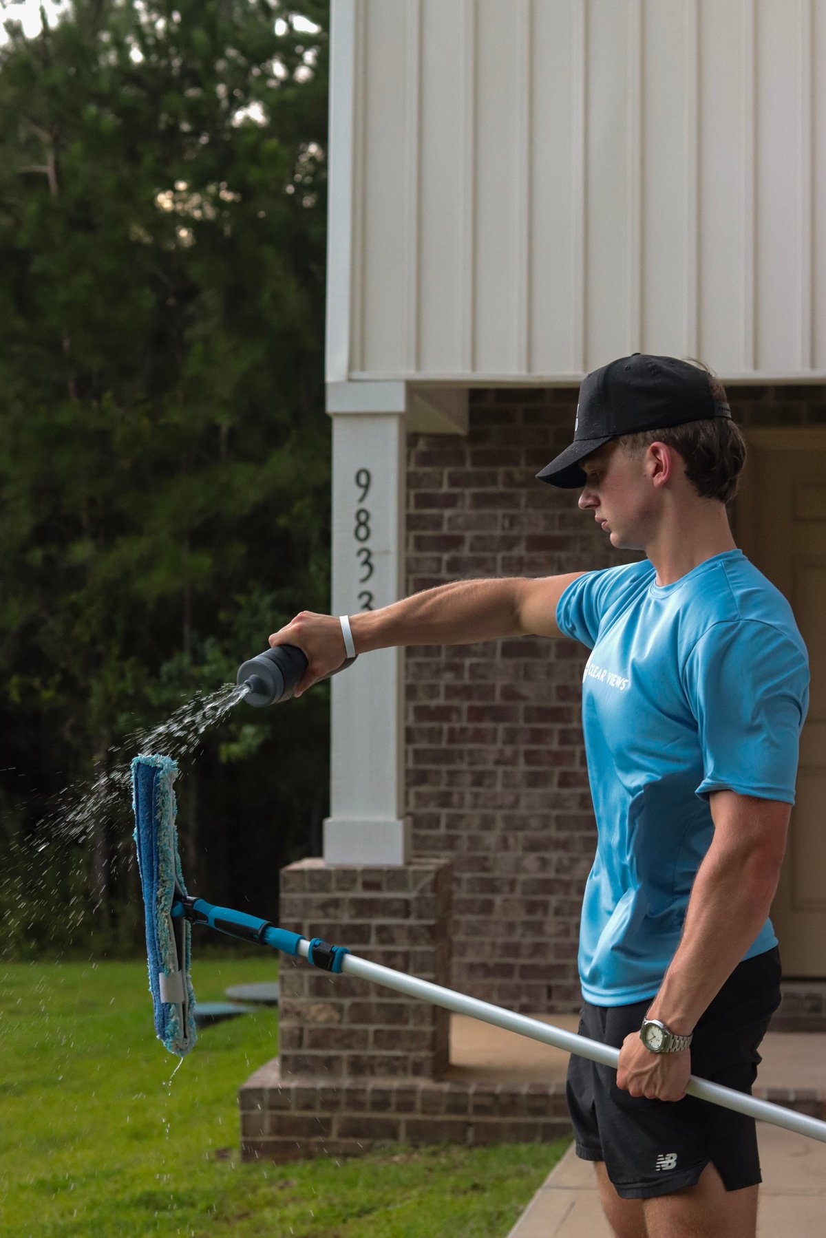 Clear Views technician spraying water on a residential window